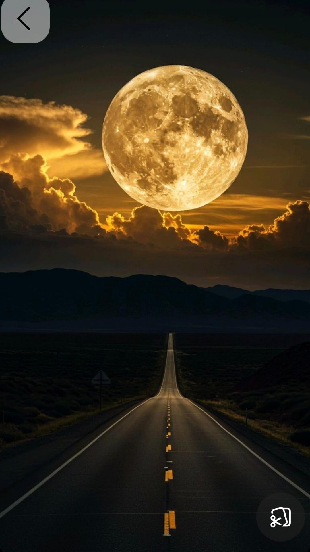 A long, straight road stretches towards the horizon, disappearing into the distance. The road is lined with yellow markers on the right side and a white line on the left. In the background, dark mountains form a silhouette against a dramatic sky. A large, luminous full moon hangs high in the sky, surrounded by glowing clouds tinged with orange and 