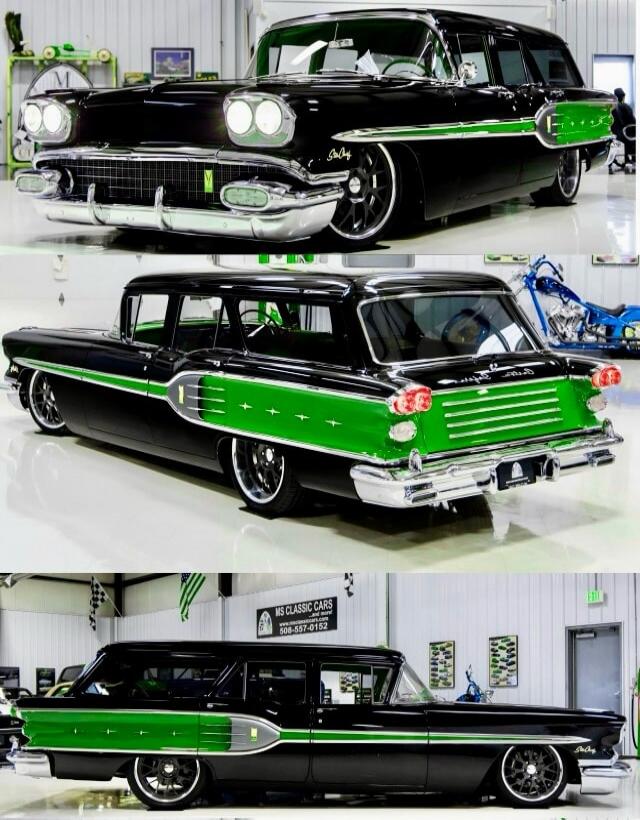 1950s Chevrolet Nomad in black and green with chrome accents, shown as a vintage two-tone station wagon in a showroom.