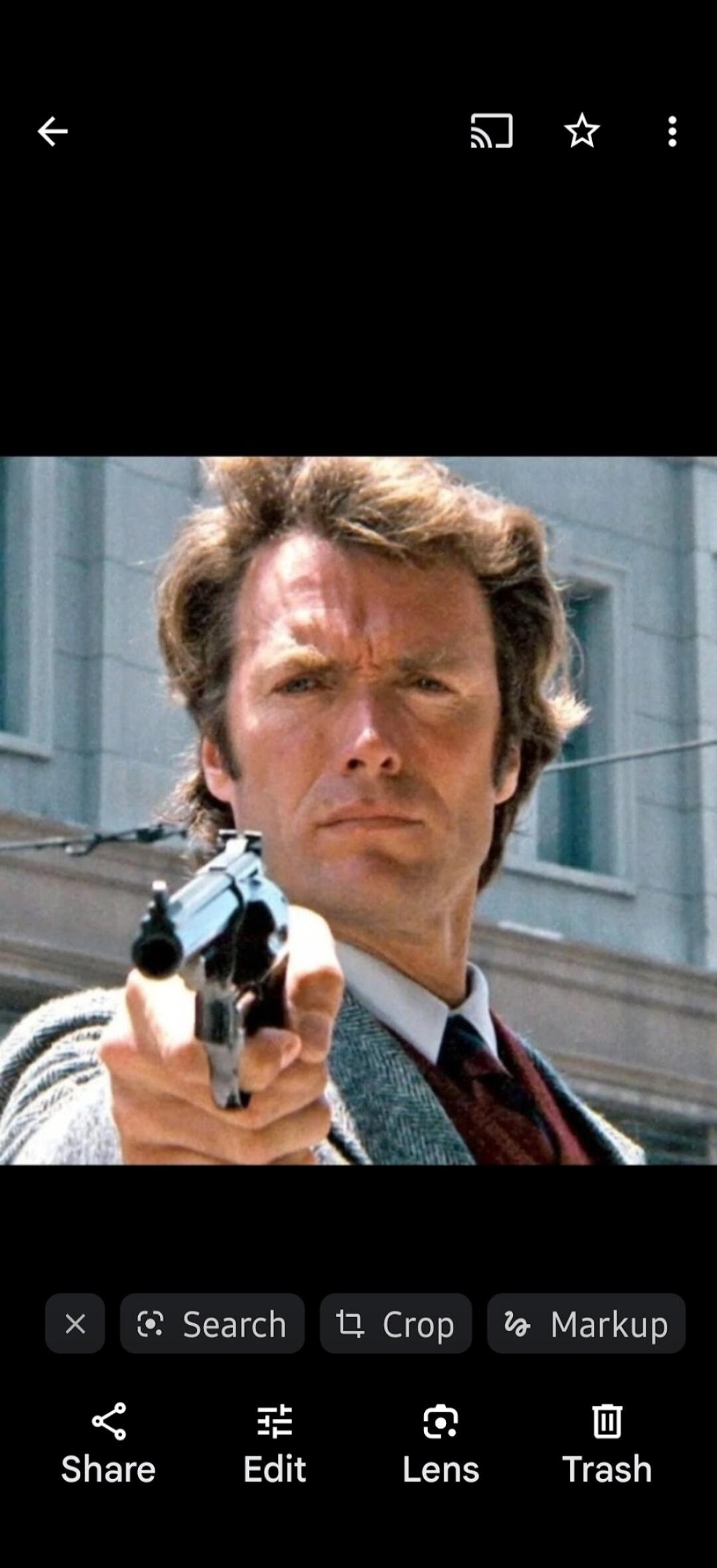 A man with an intense gaze points a revolver directly at the viewer.