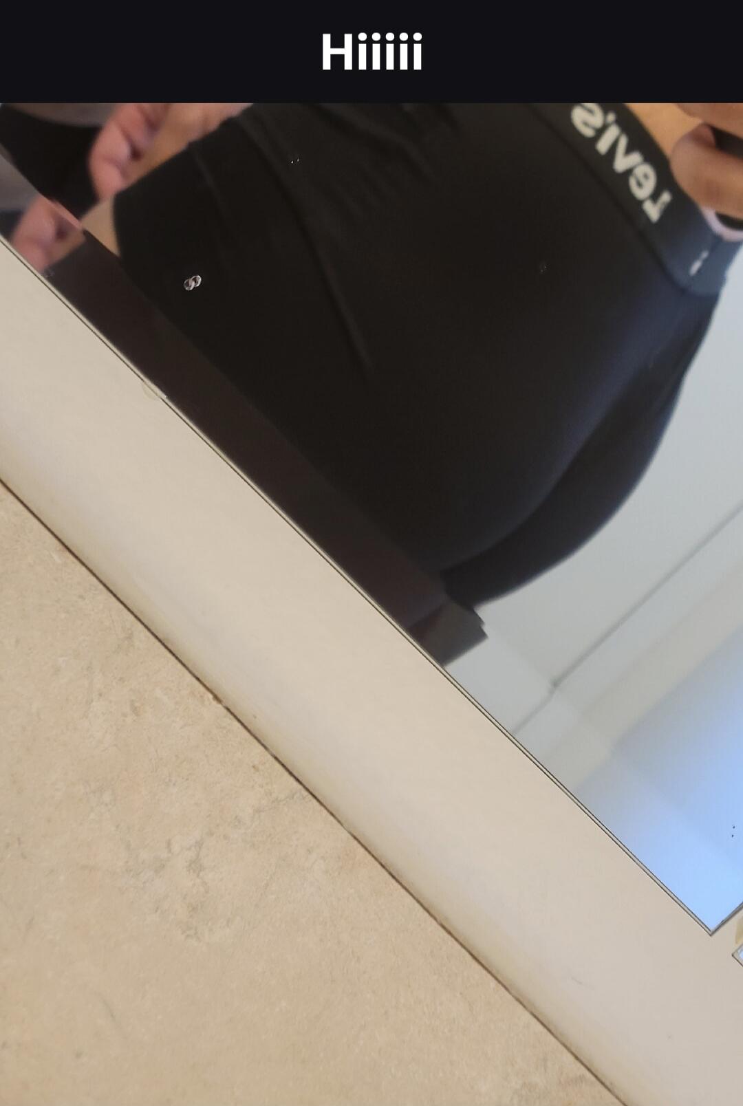 Hiiii. A person is taking a mirror selfie, focusing on their buttocks, wearing black leggings and underwear with a visible brand name.