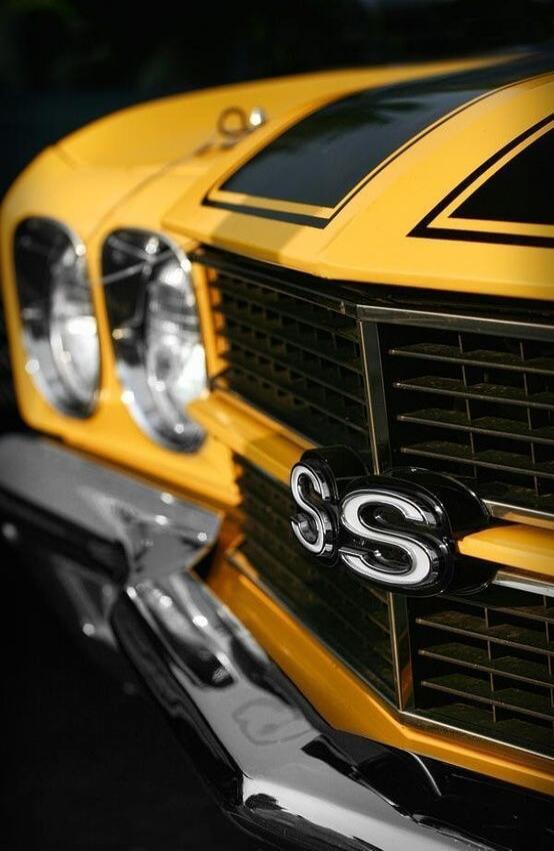 SS badge on the front grill of a yellow vintage car