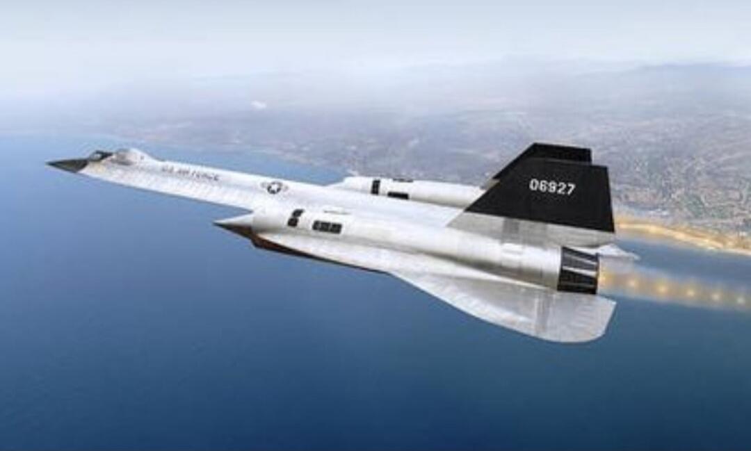 A white U.S. Air Force aircraft, resembling a reconnaissance plane like the A-12 or SR-71, flying over the ocean with a coastline in the background. The tail fin displays the number 06927. The aircraft's engines are emitting a fiery exhaust, indicating high-speed flight.