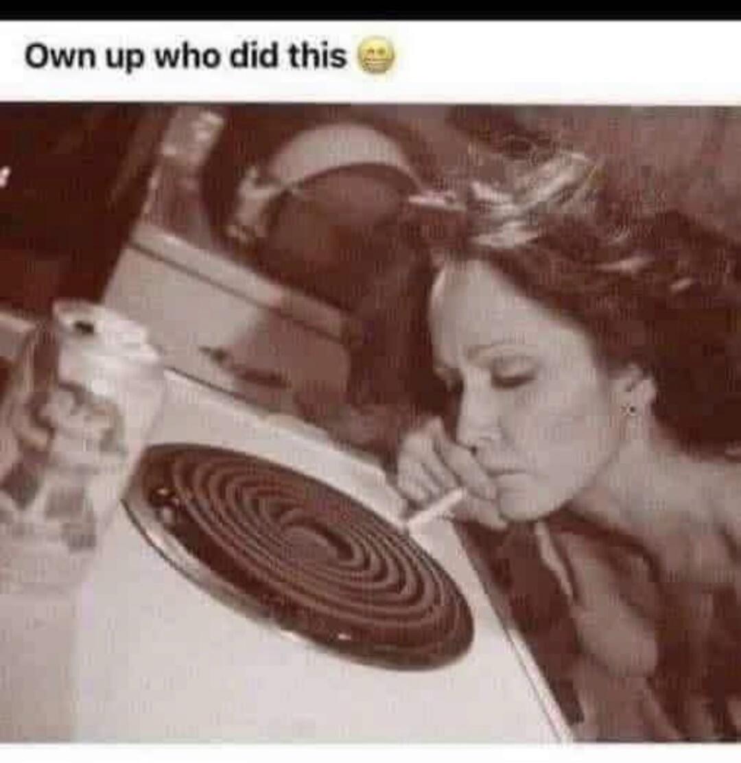 Own up who did this 😂. A woman is lighting a cigarette on an electric stove burner.
