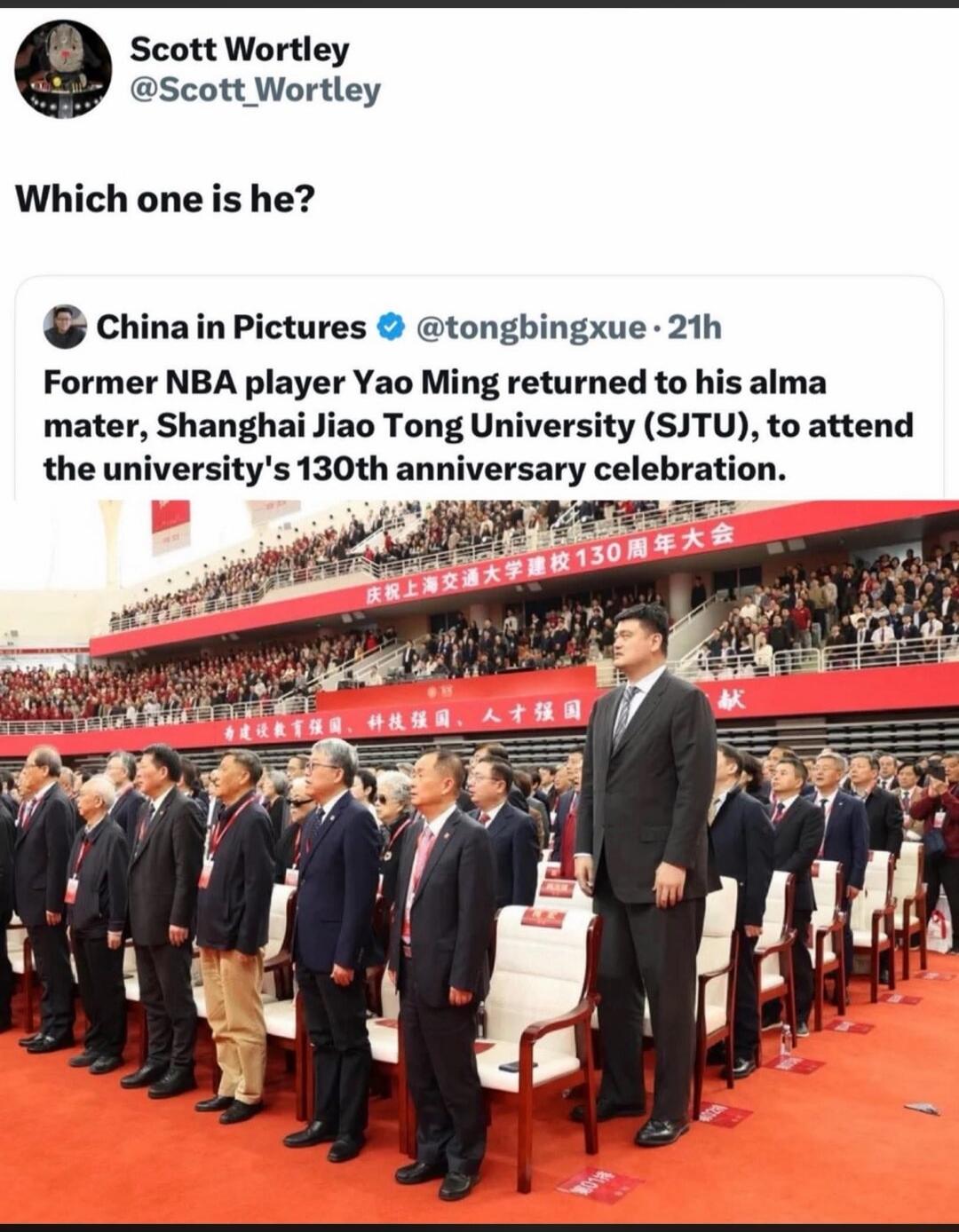 Scott Wortley asks 'Which one is he?' referring to former NBA player Yao Ming, who returned to his alma mater, Shanghai Jiao Tong University, to attend the university's 130th anniversary celebration. Yao Ming is visibly much taller than everyone else in the crowd.
