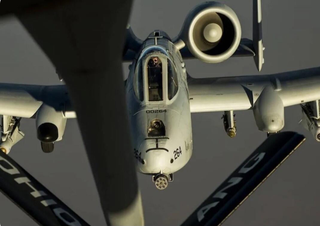 00264, 264, OHIO, ANG. An A-10 Thunderbolt II aircraft, also known as the Warthog, is shown in flight, possibly during aerial refueling. The pilot is visible in the cockpit.