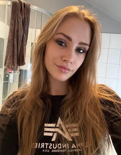 A young woman posing for a selfie in a bathroom.