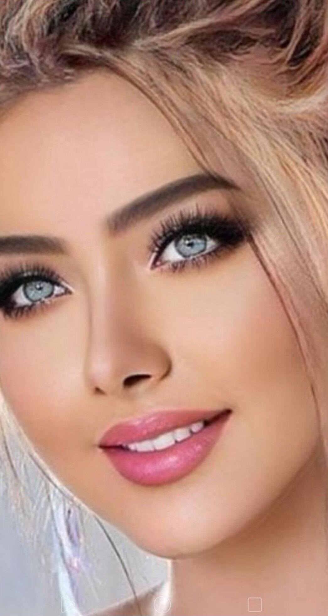 Close-up portrait of a woman with light blonde hair, blue eyes, and pink lips.