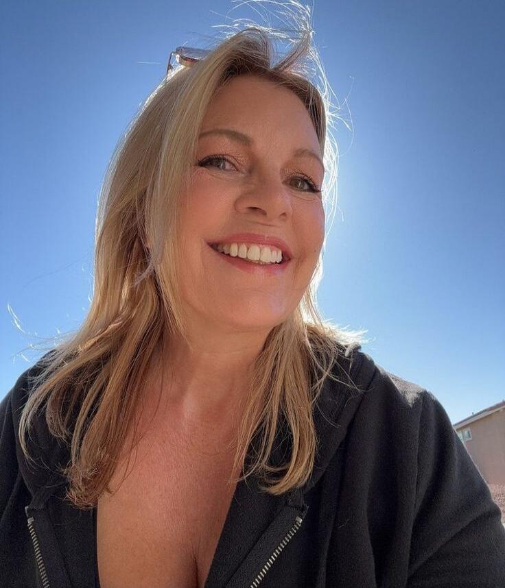 Portrait of a smiling woman outdoors on a sunny day.