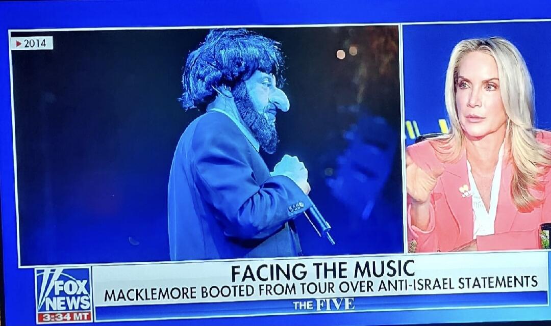 A Fox News broadcast from 2014, showing a split screen. On the left, a man with a large prosthetic nose and beard, resembling a caricature, is on stage holding a microphone. On the right, a woman with blonde hair in a pink blazer is speaking. The on-screen text reads: 'FACING THE MUSIC', 'MACKLEMORE BOOTED FROM TOUR OVER ANTI-ISRAEL STATEMENTS', an