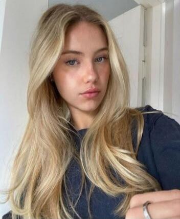 Photo of a young blonde woman taking a selfie.