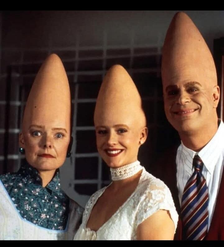 Three people wearing cone-shaped heads reminiscent of the Coneheads from SNL (Saturday Night Live).