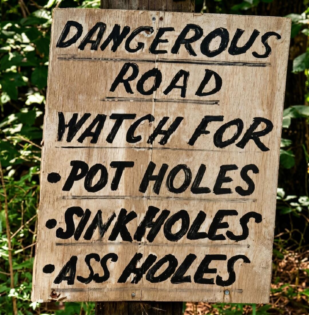 DANGEROUS ROAD WATCH FOR • POT HOLES • SINKHOLES • ASS HOLES