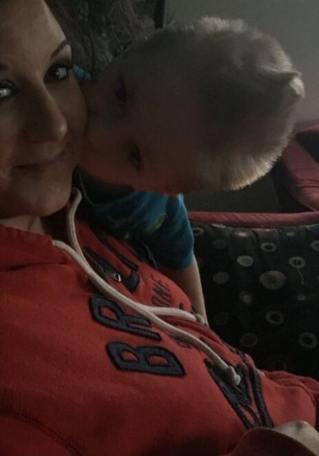 A baby is kissing a woman's cheek.