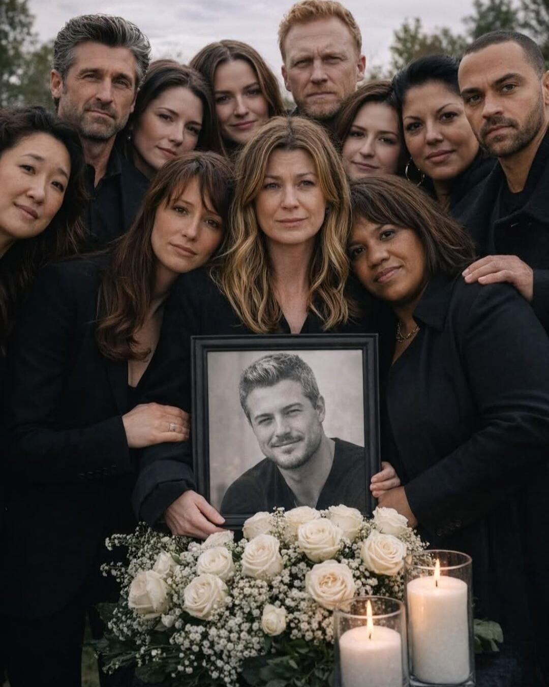 Group of people dressed in black gather around a framed black-and-white photo of a man, surrounded by white roses and lit candles, suggesting a memorial or funeral scene.