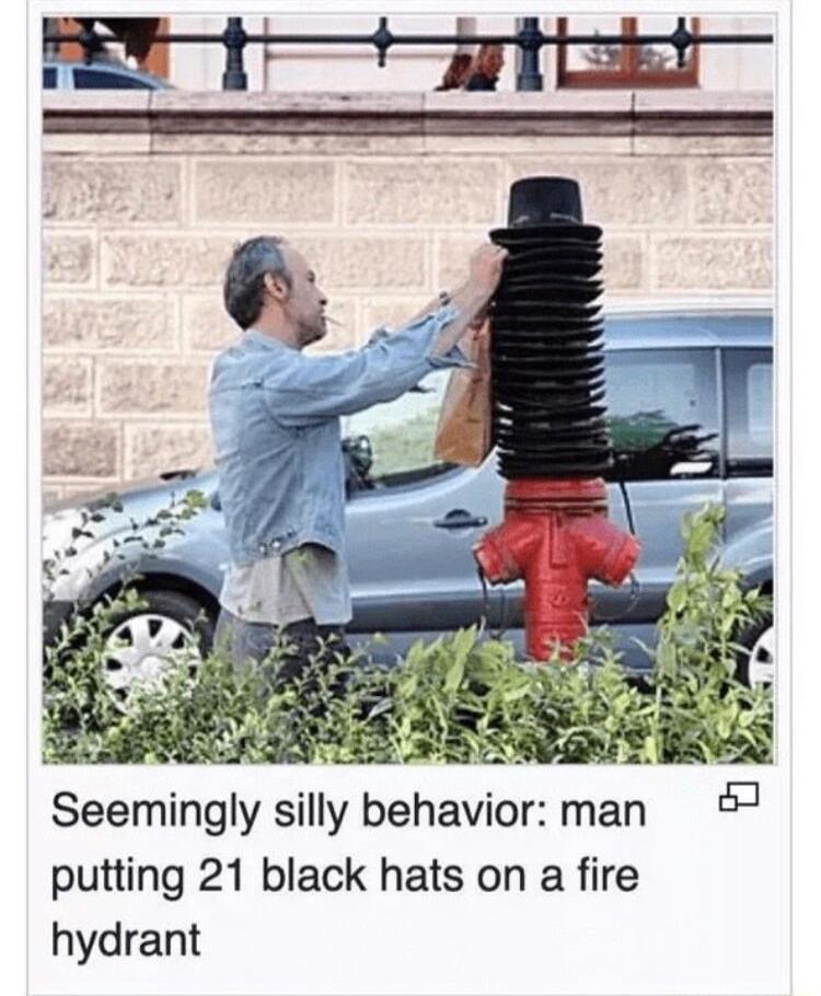 Seemingly silly behavior man 7 putting 21 black hats on a fire hydrant