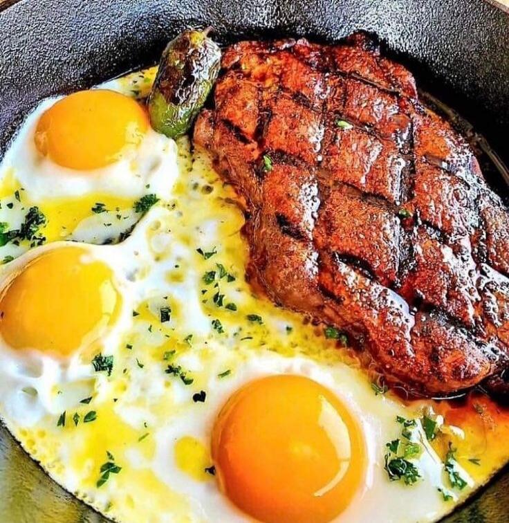 Skillet meal with a seared steak and sunny-side-up eggs.