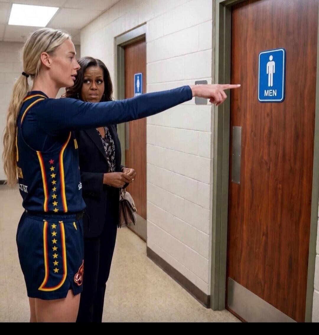 A woman in a basketball uniform points to a men's restroom door, while Michelle Obama stands next to her, looking at the door. The sign on the door clearly says 'MEN'.