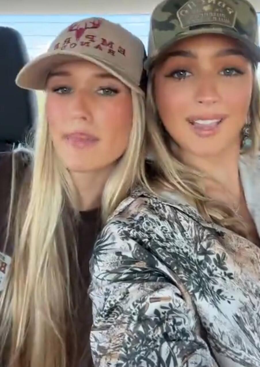 Two women sitting in a car wearing hats.