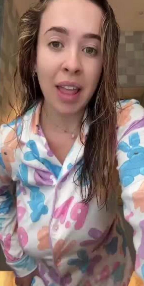 A woman is speaking to the camera, possibly sharing details about her day or her comfortable bunny pajamas after a shower.