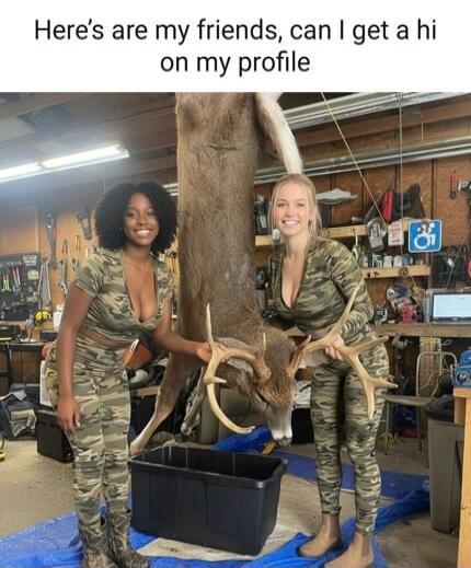 Here are my friends, can I get a hi on my profile. Two women in camouflage outfits posing with a large, dead deer hanging upside down.