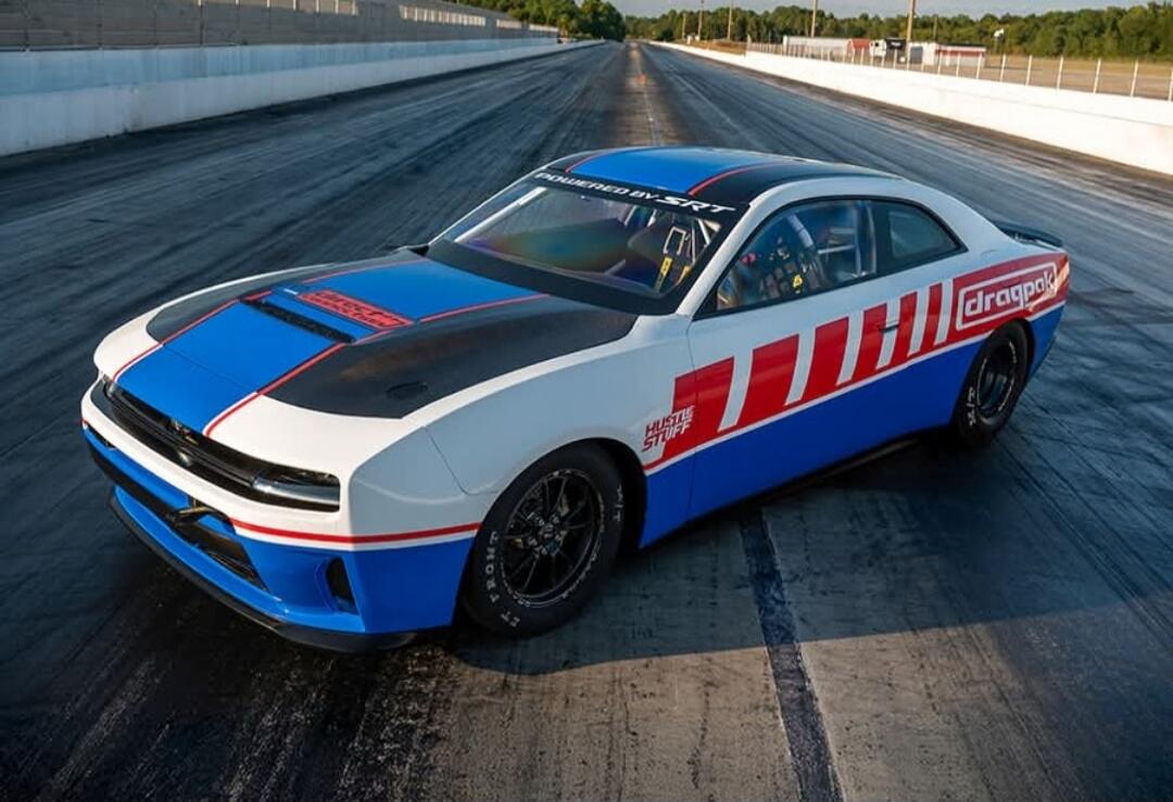 A blue, white, and red race car on a drag strip.