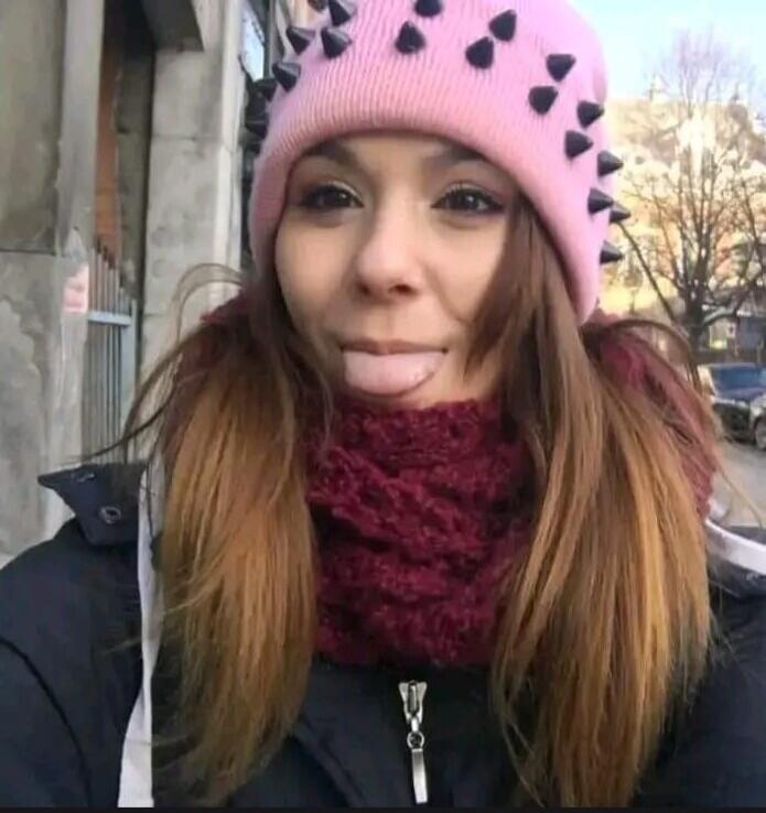 The girl is sticking out her tongue and making a funny face.