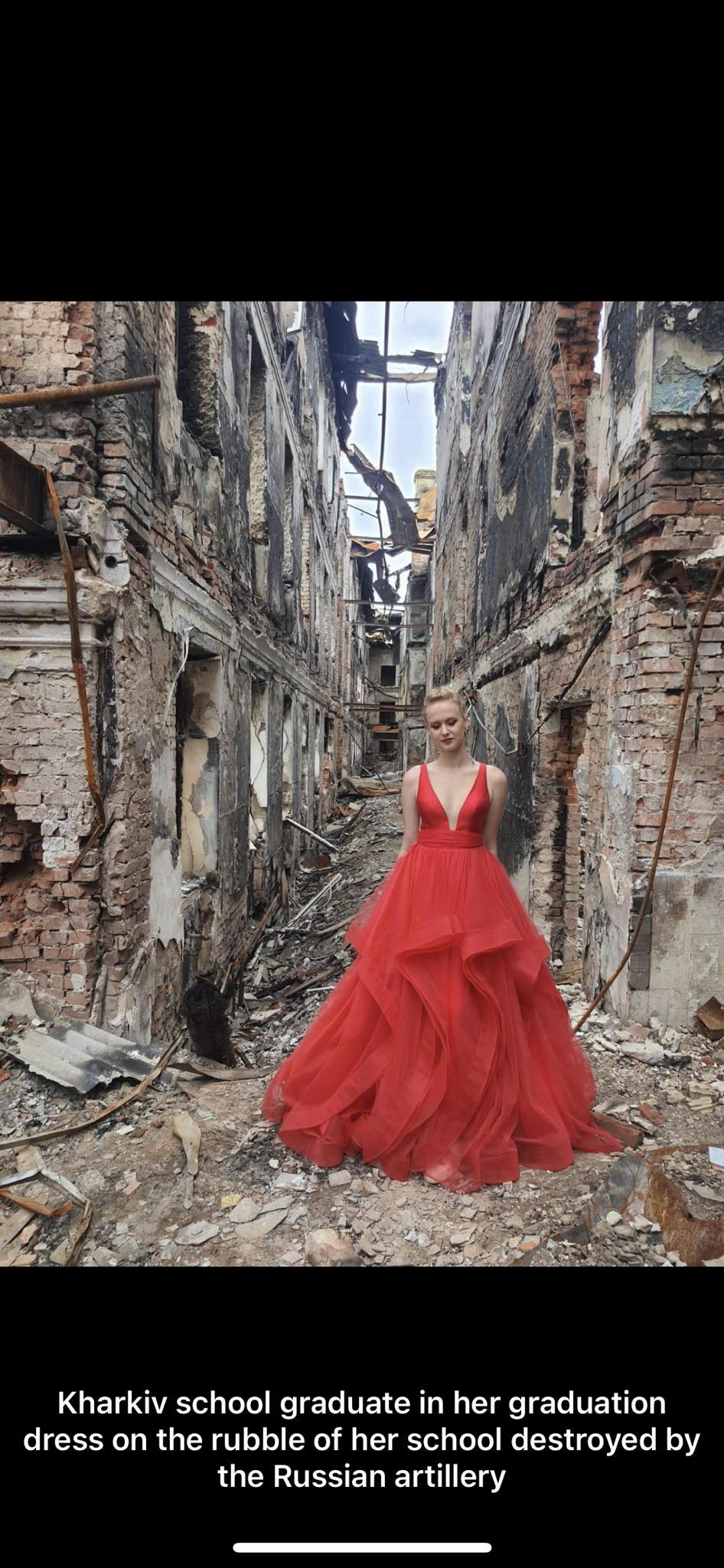 GET S I Tl TELER T B Y e T TELT dress on the rubble of her school destroyed by the Russian artillery