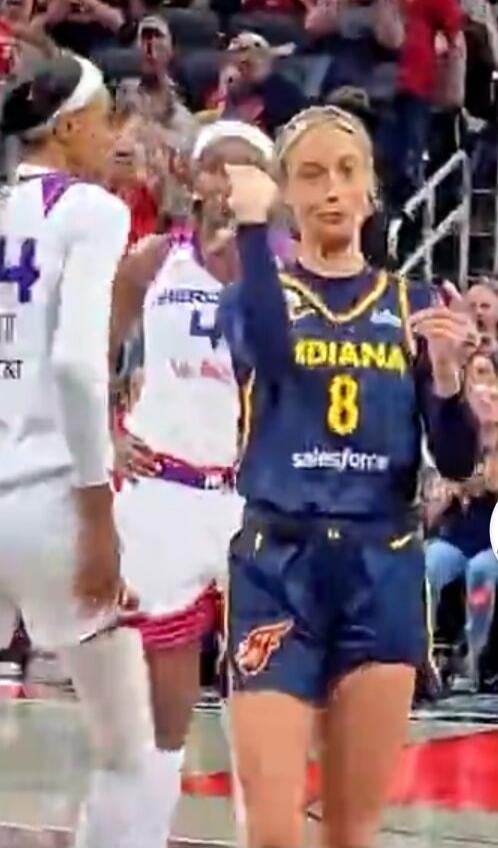 A female basketball player in a blue Indiana jersey with number 8 and 'salesforce' logo makes a shush gesture. Another player in a white jersey with number 4 and 'HERO AT&T' logo is visible in the background.
