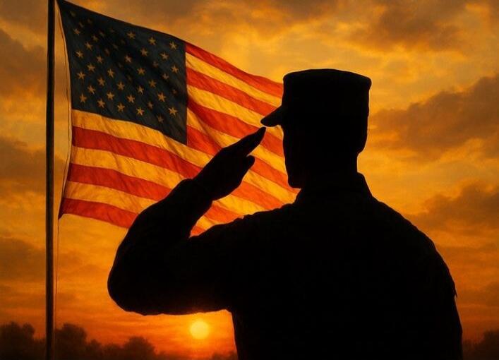 Silhouetted soldier saluting in front of an American flag at sunset.