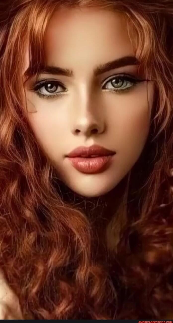 Portrait of a young woman with red curly hair and makeup.