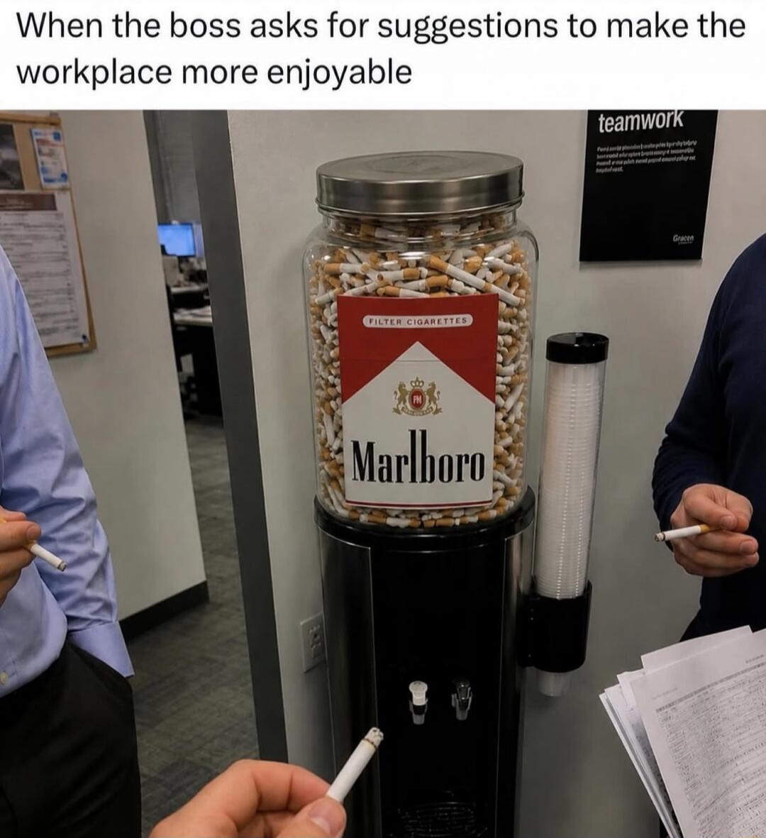 When the boss asks for suggestions to make the workplace more enjoyable. Filter Cigarettes Marlboro. The image shows a water cooler dispenser filled with cigarettes instead of water, with people holding cigarettes, implying this is a humorous suggestion for a more enjoyable workplace.