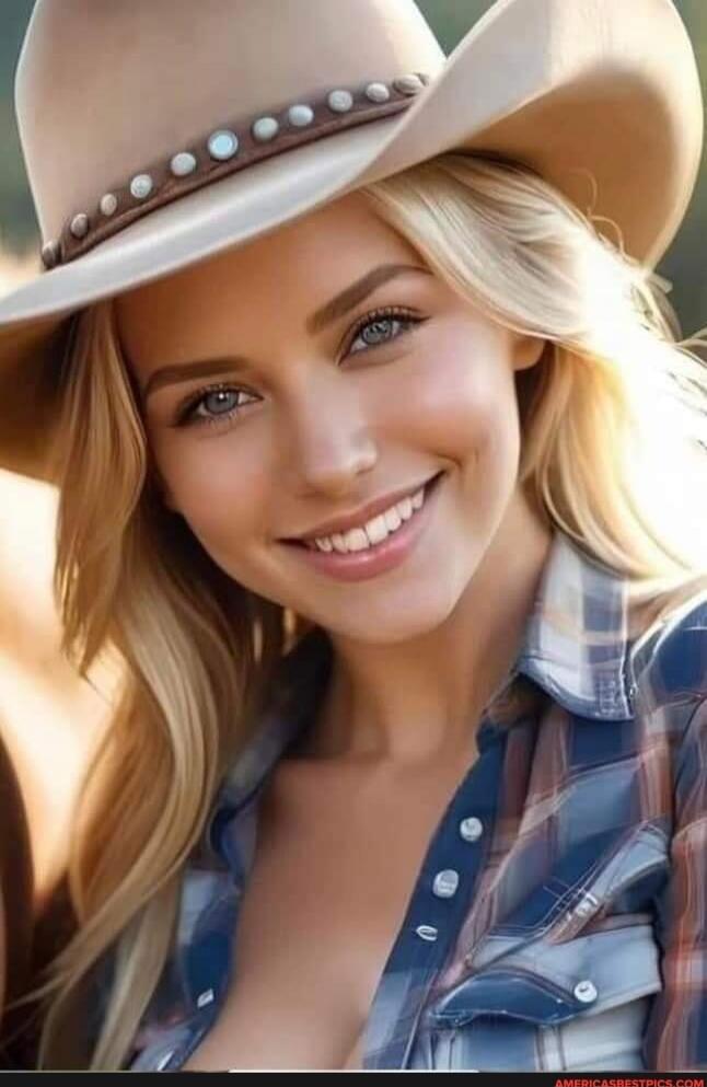 A smiling woman wearing a wide-brimmed hat with studs and a plaid shirt.