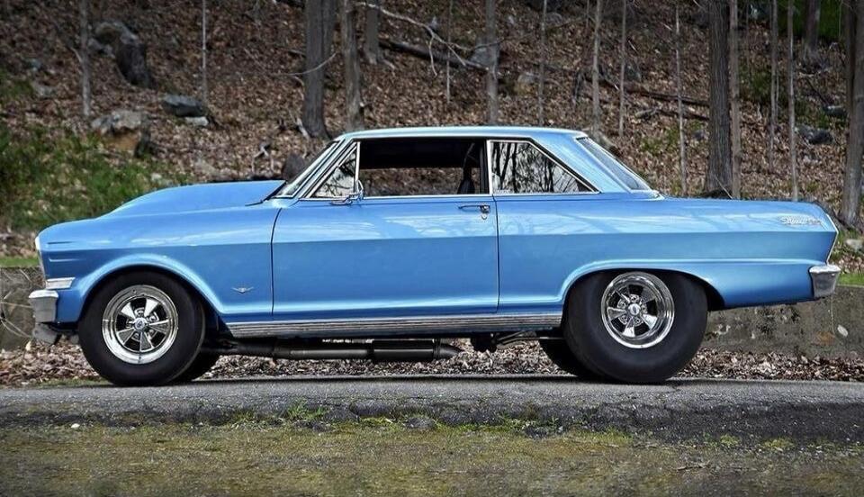 Blue classic car on the road (side view).