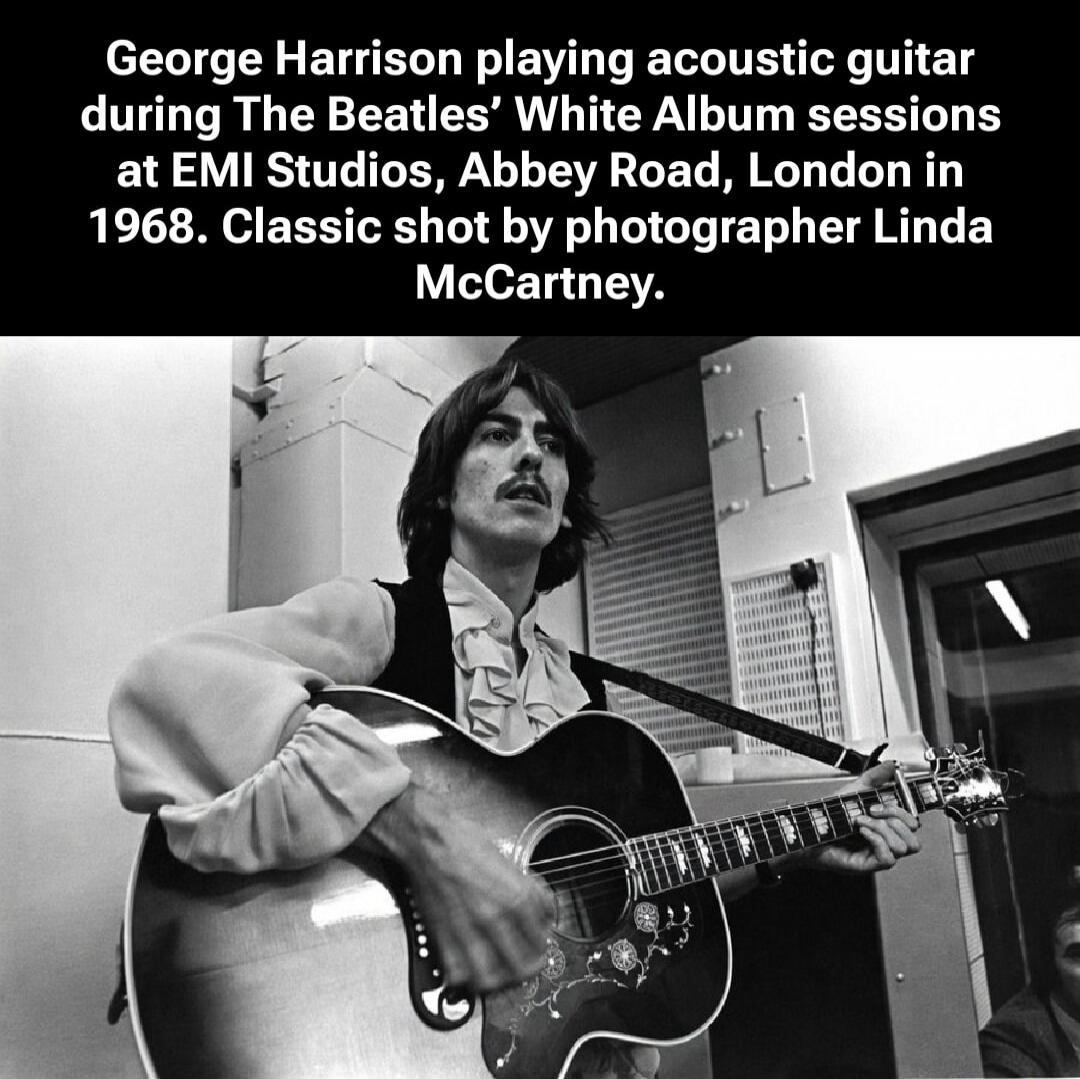 George Harrison playing acoustic guitar during The Beatles' White Album sessions at EMI Studios, Abbey Road, London in 1968. Classic shot by photographer Linda McCartney.