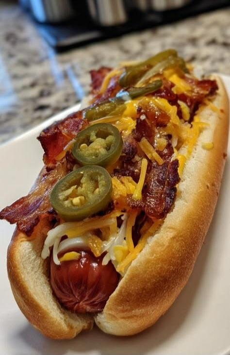 A delicious hot dog with bacon, cheese, and jalapeños.