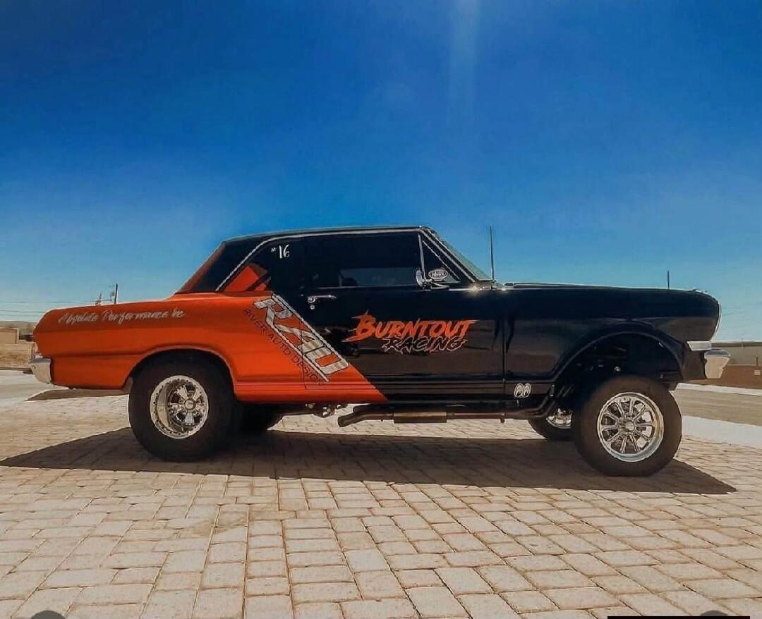 A customized classic car, possibly a Chevrolet Nova, with a gasser-style stance. The car is black and orange, featuring 'BURNOUT RACING' on the side, 'RIVER AUTO DESIGN' on the rear quarter panel, and 'Absolute Performance' on the trunk lid. A number '*16' is visible on the rear window.