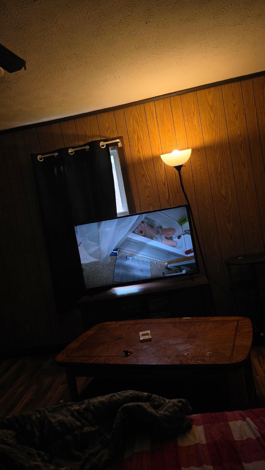 A baby or doll is seen in a bathtub, possibly being bathed.