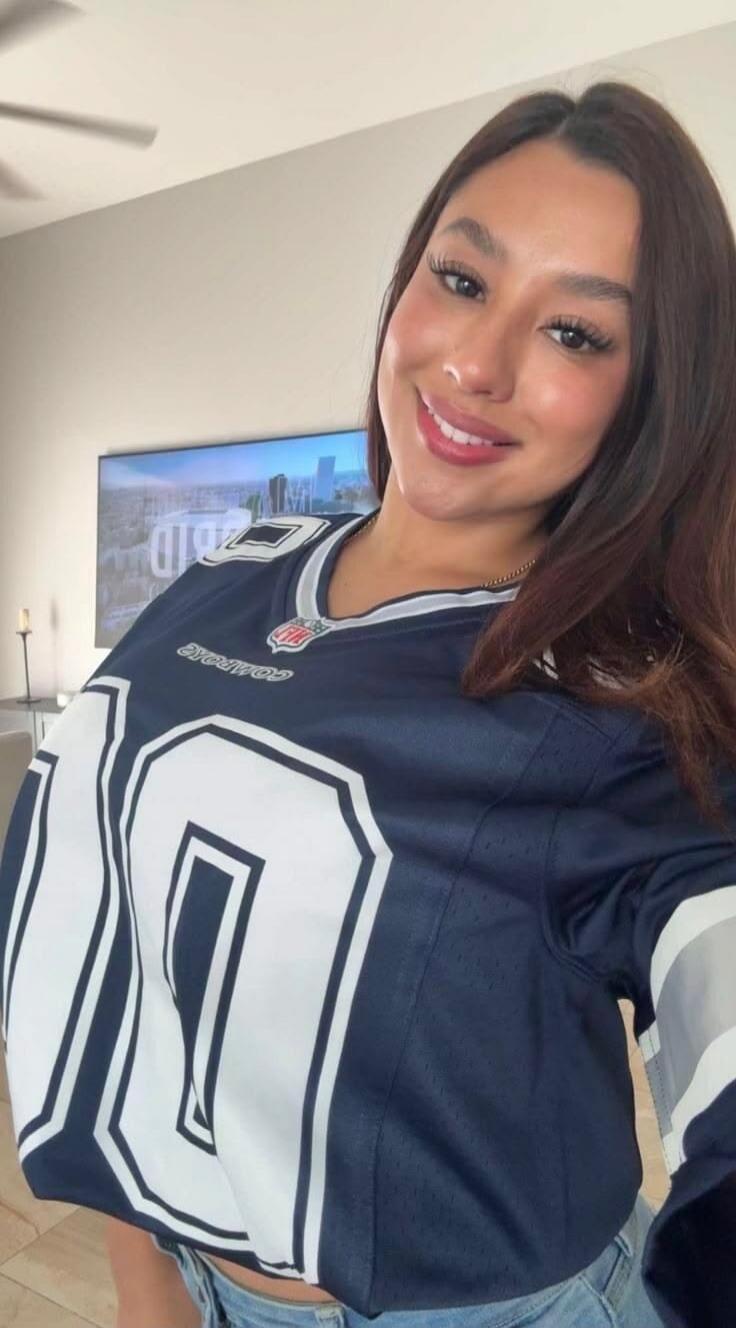 A woman wearing a Dallas Cowboys jersey with the number 20 or 21, smiling at the camera. The text 'COMPARE' and 'NFL' is visible on the jersey.