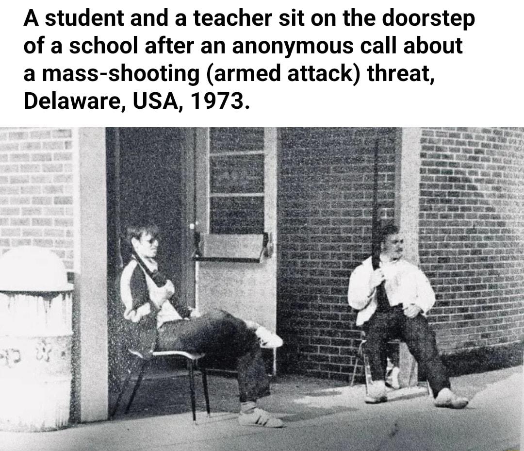 A student and a teacher sit on the doorstep of a school after an anonymous call about a mass shooting armed attack threat Delaware USA 1973