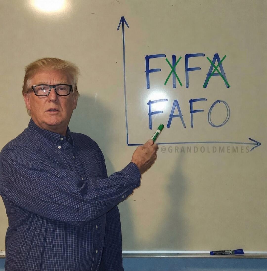 A man resembling Donald Trump is pointing at a whiteboard. On the whiteboard, the text 