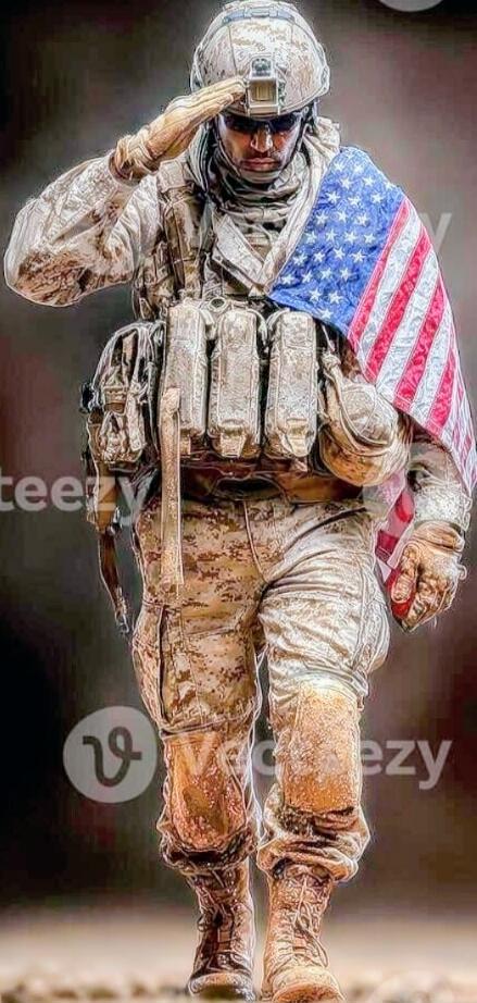 A soldier in desert camouflage saluting while holding an American flag.