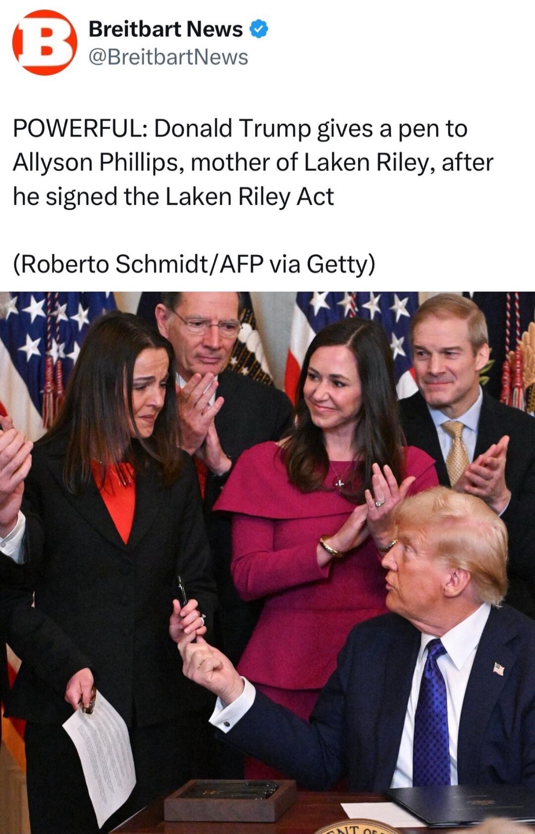 Breitbart News Breitb POWERFUL Donald Trump gives a pen to Allyson Phillips mother of Laken Riley after he signed the Laken Riley Act