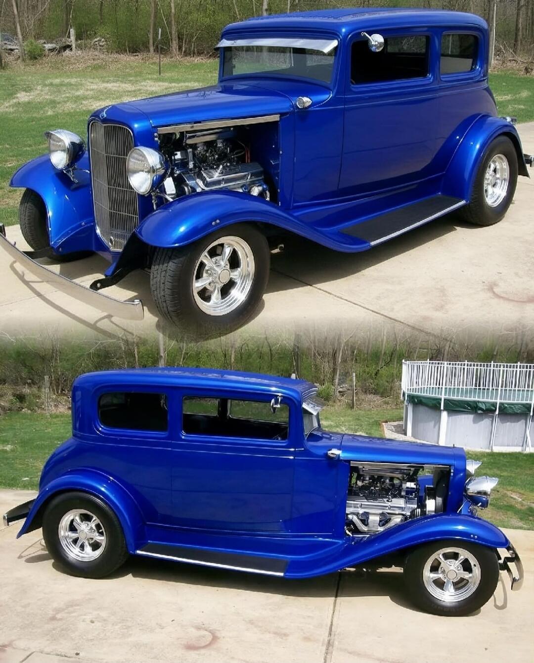 A vibrant blue classic hot rod car is parked on a concrete driveway. The car features an exposed engine, chrome accents, and custom wheels. The background shows a grassy area with trees and an above-ground swimming pool.
