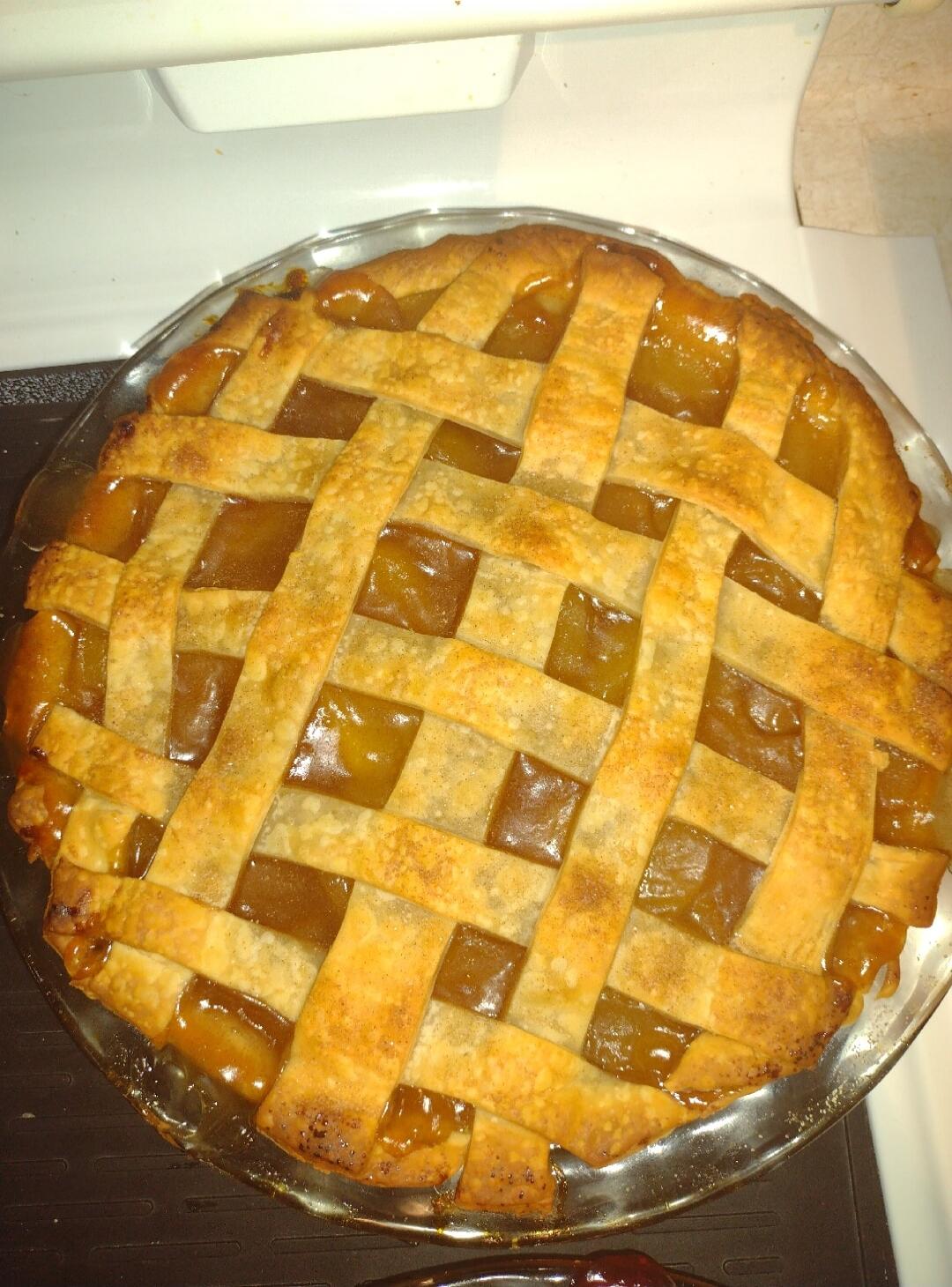 Pie with a lattice crust over caramel-colored filling.