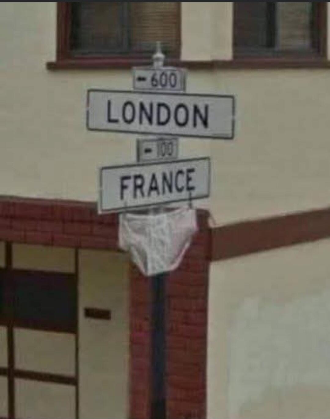 LONDON - 600, FRANCE - 100. A pair of white briefs is hung on a street sign pole, humorously resembling a basketball net.