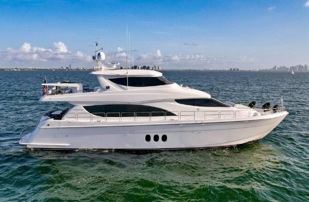 A white luxury yacht cruising on calm blue water.