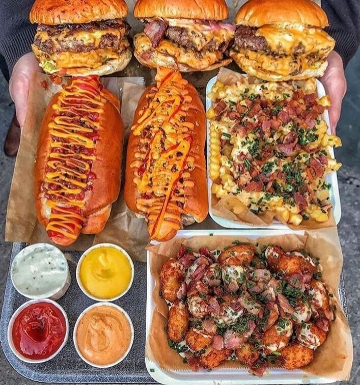 Assorted burgers, hot dogs, loaded fries, sauces, and fried chicken bites.
