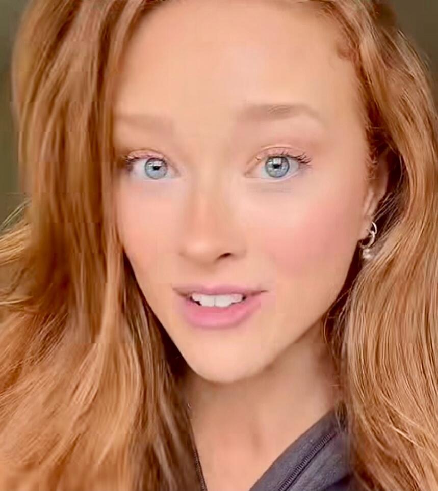 A woman is speaking to the camera.