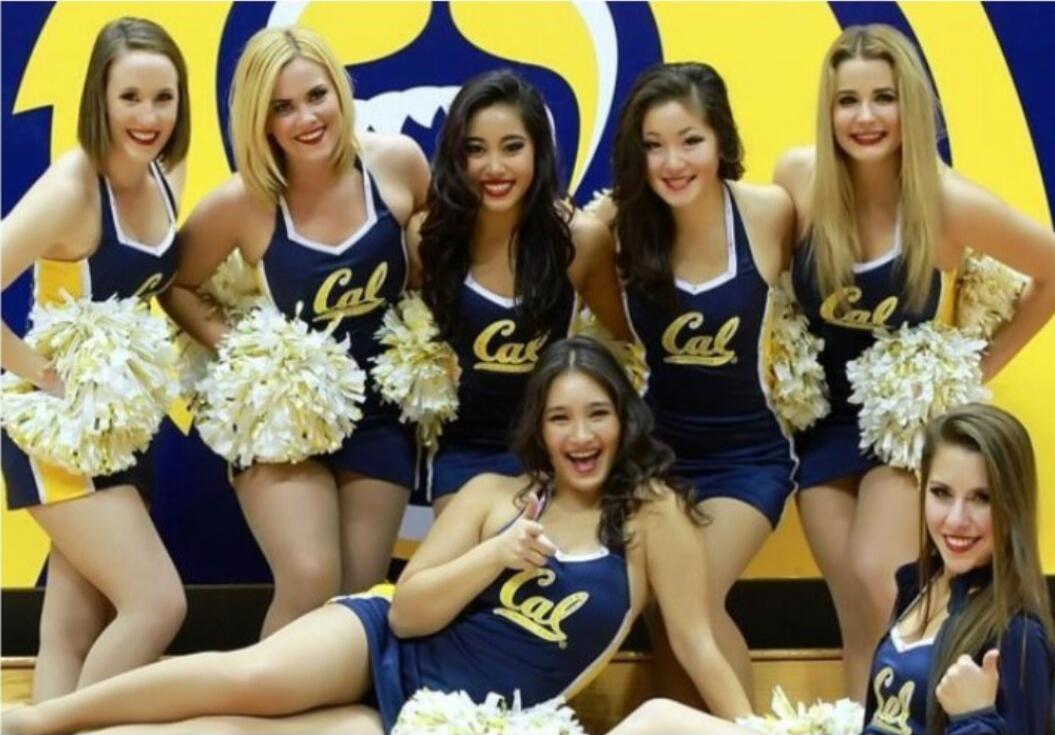 Cal cheerleaders posing for a group photo in blue and gold uniforms.
