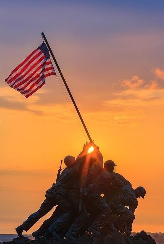 US Marines raising the American flag on a rock at sunset (iconic Iwo Jima moment).